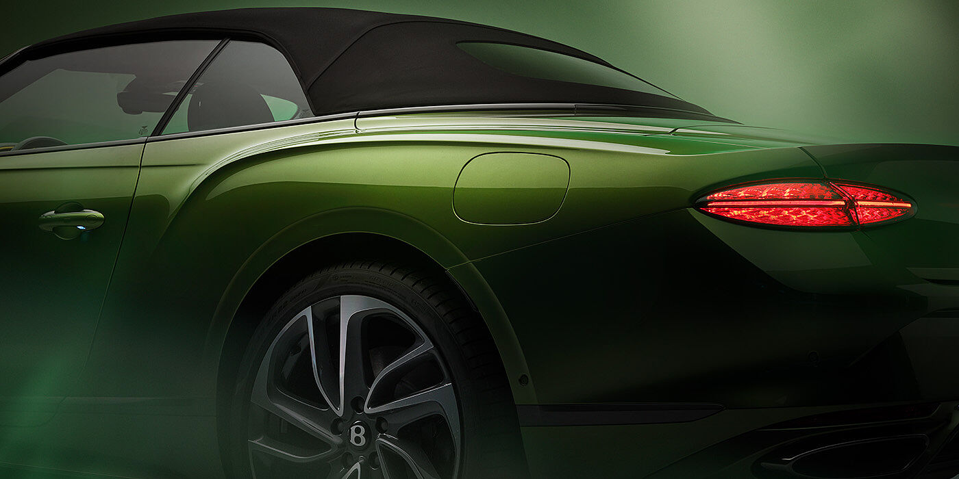 Bentley Stockholm Bentley New Continental GTC Speed rear haunch and tail lamp in Tourmaline Green paint and dark tint brightware with black hood up and illuminated head lamps